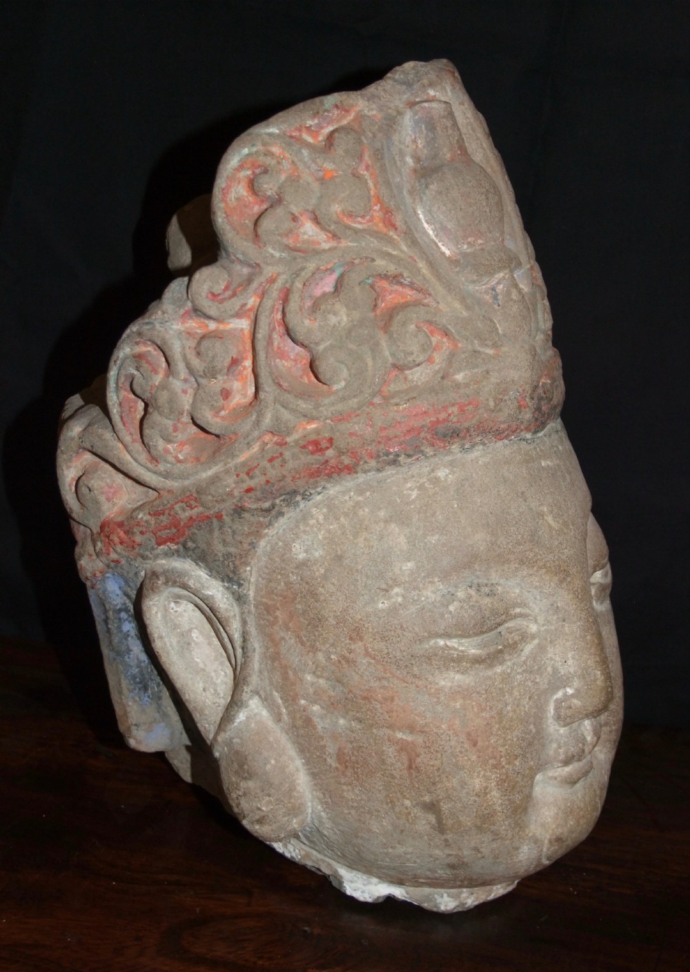 Carved sandstone head of Avalokiteshvara featuring an elaborate crown, gentle facial contours, and visible traces of red and green pigment. View IV