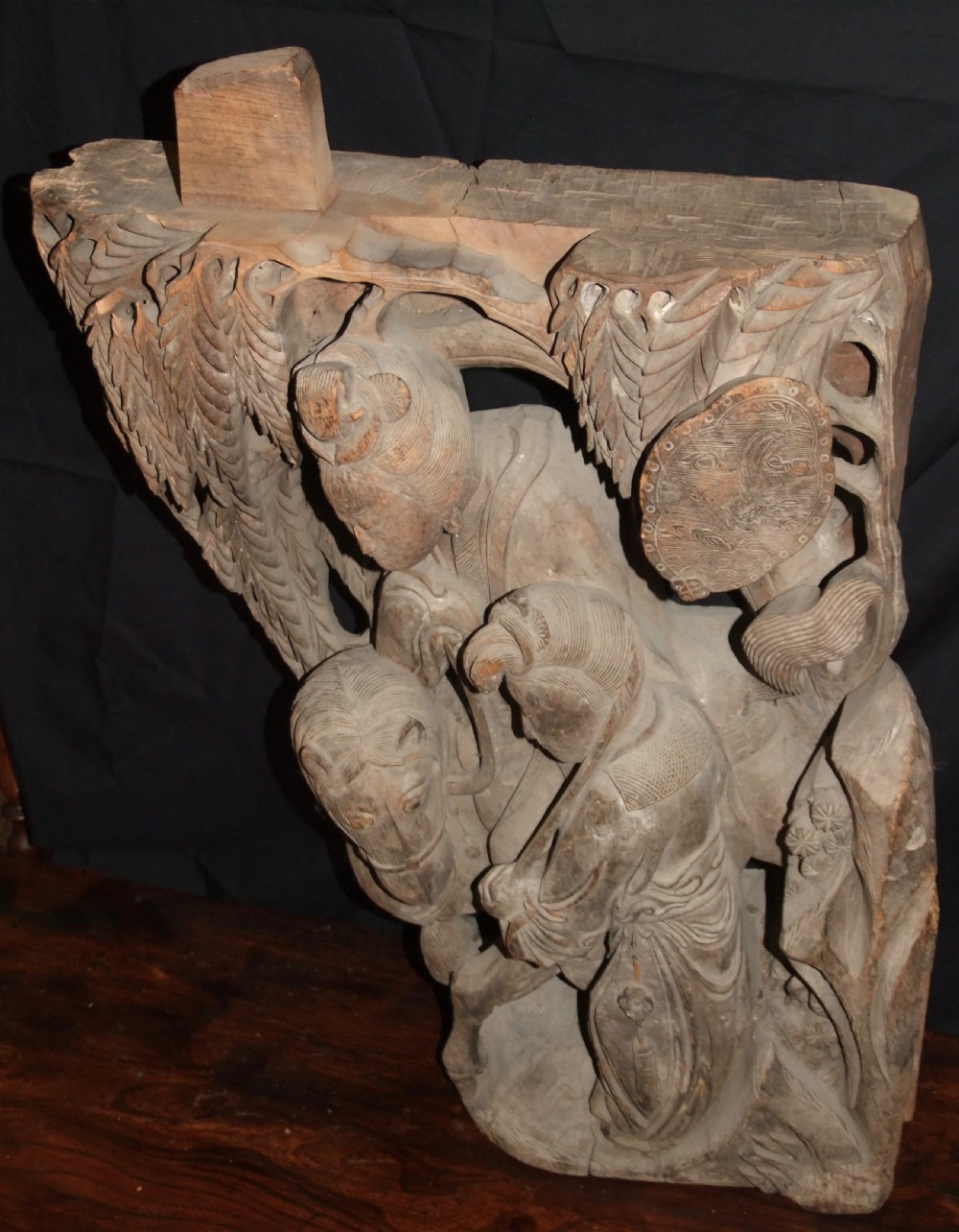A pair of deeply carved natural timber architectural corbels depicting figures mounted on horses amidst floral motifs. View XI