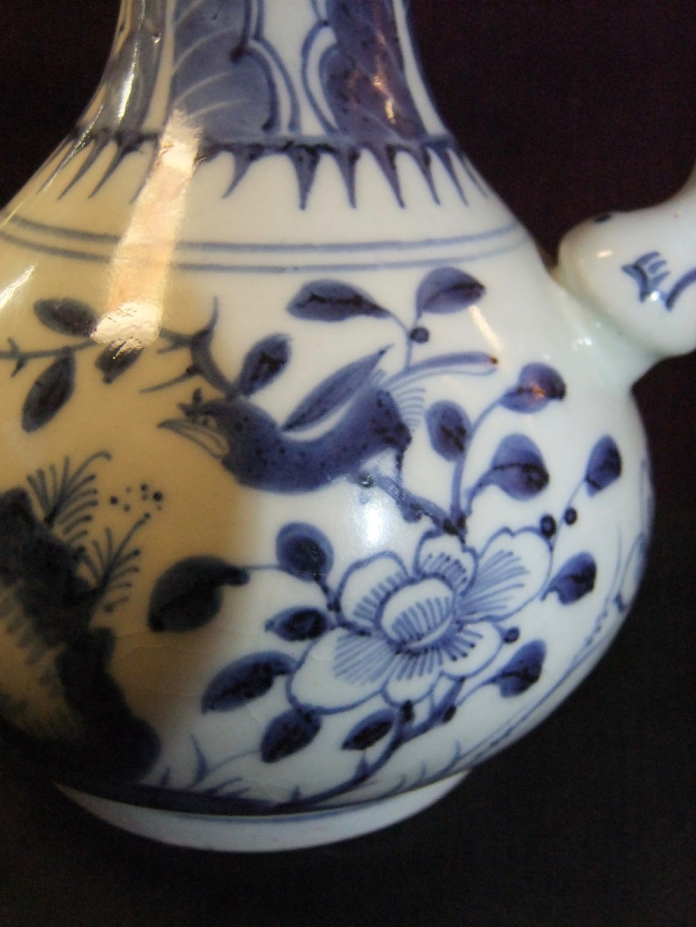 A Chinese blue and white porcelain kendi water vessel from the Kangxi period with floral and bird decoration and a bulbous side spout. View II
