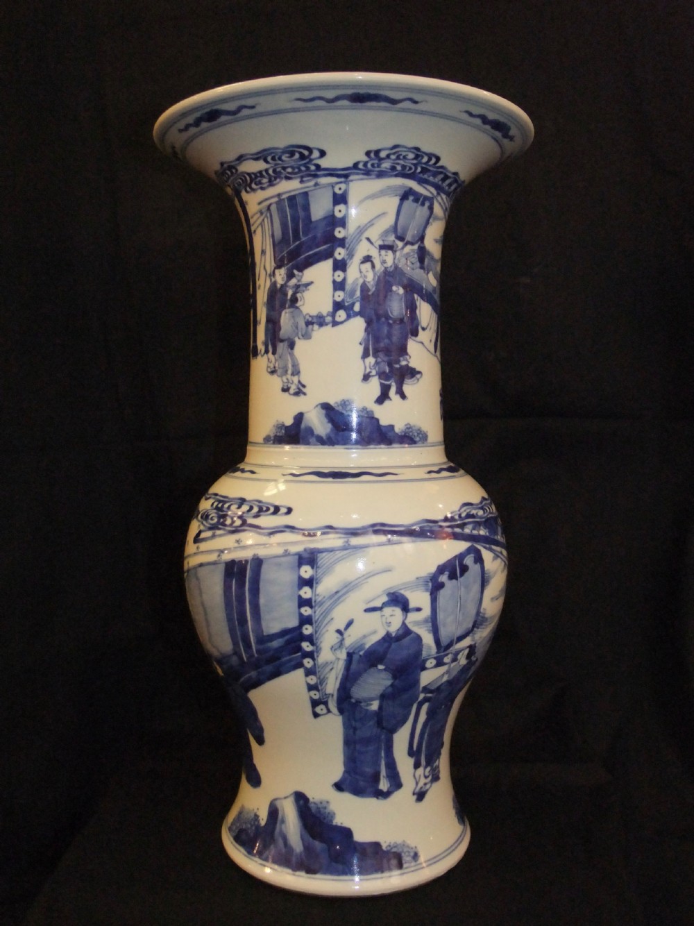 An antique Chinese blue and white porcelain Yen Yen vase featuring a flared trumpet rim and narrative figurative panels painted in underglaze cobalt blue.