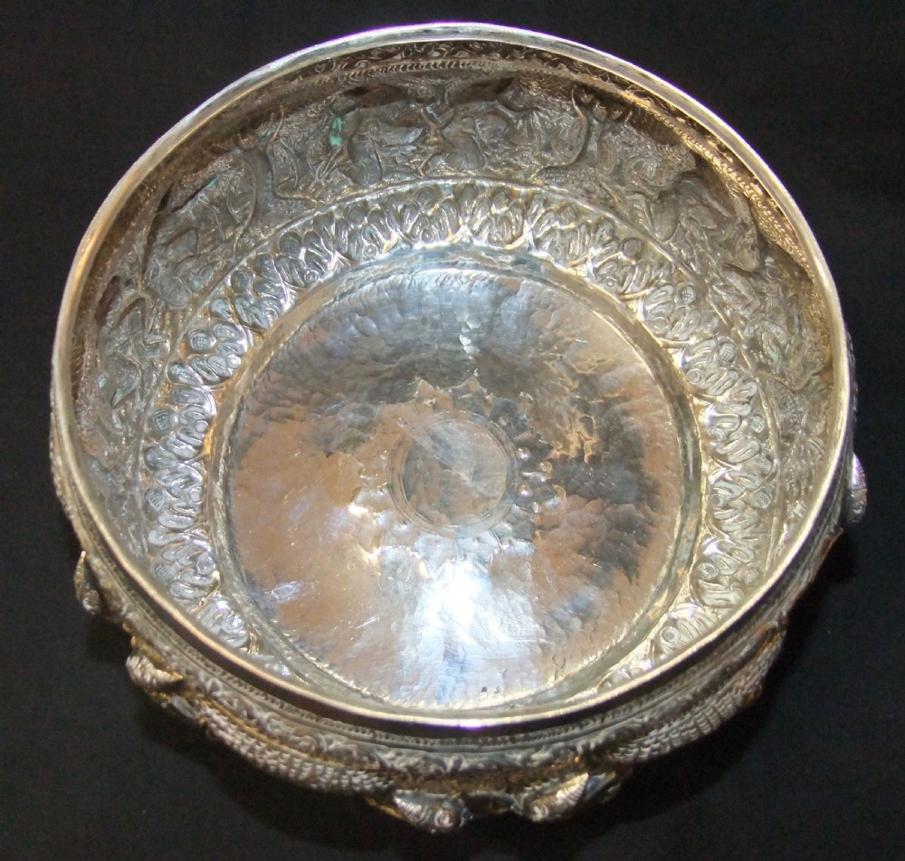 A 19th-century Burmese footed silver bowl featuring high-relief repousse decoration depicting figures, animals, and trees. View VII