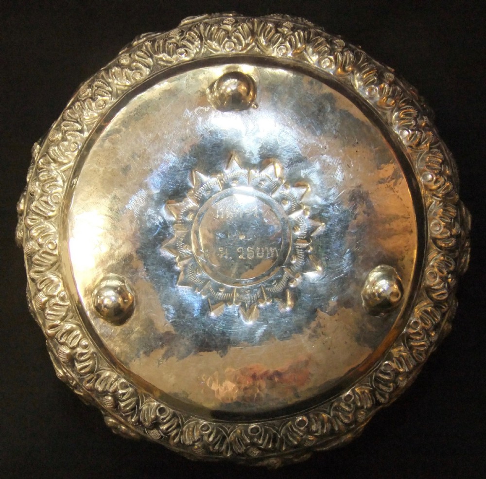 A 19th-century Burmese footed silver bowl featuring high-relief repousse decoration depicting figures, animals, and trees. View VIII