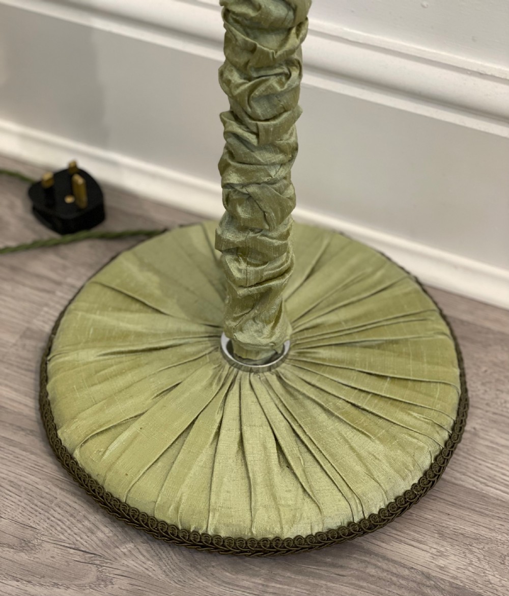 A 1930s standard lamp with gathered sage green silk fabric covering the central column and circular base, topped with a chrome bulb fitting. View V