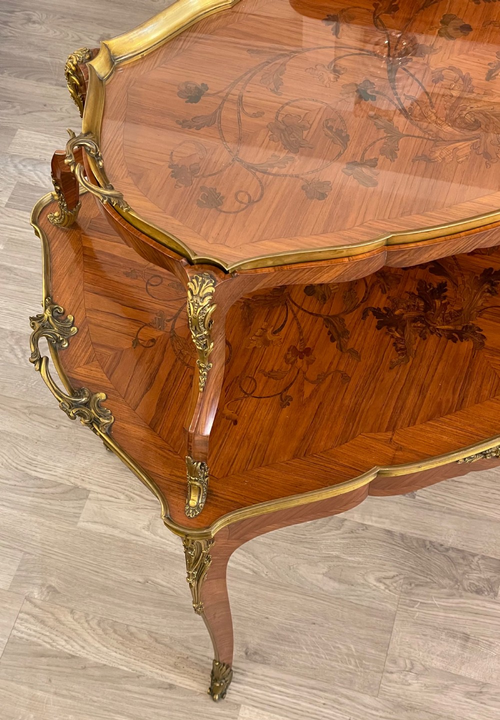 A late 19th-century French kingwood two-tier etagere table with gilt-bronze mounts, floral marquetry, and a glass-bottomed upper tray. View II