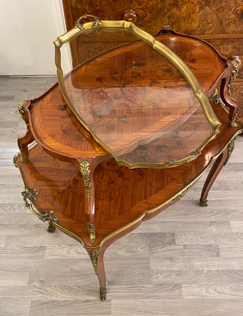 A late 19th-century French kingwood two-tier etagere table with gilt-bronze mounts, floral marquetry, and a glass-bottomed upper tray. View IX