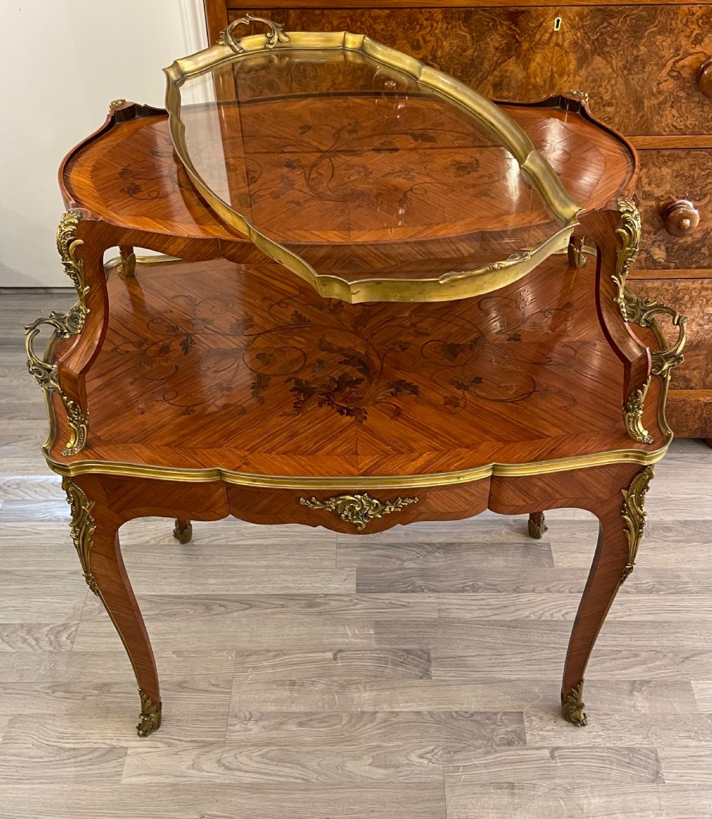 A late 19th-century French kingwood two-tier etagere table with gilt-bronze mounts, floral marquetry, and a glass-bottomed upper tray. View X