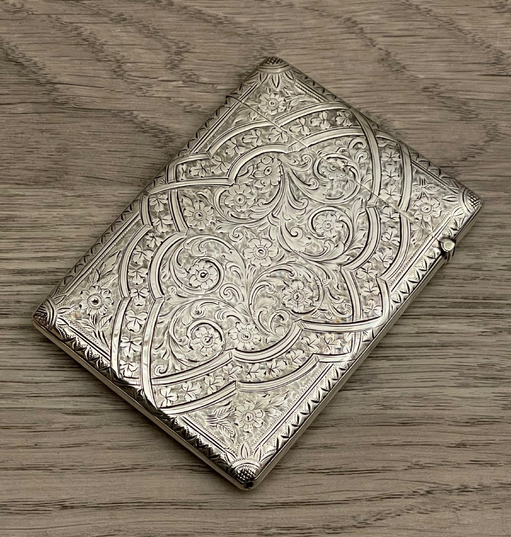 An Edwardian sterling silver calling card case featuring detailed foliate floral engraving and a central monogram cartouche. View III