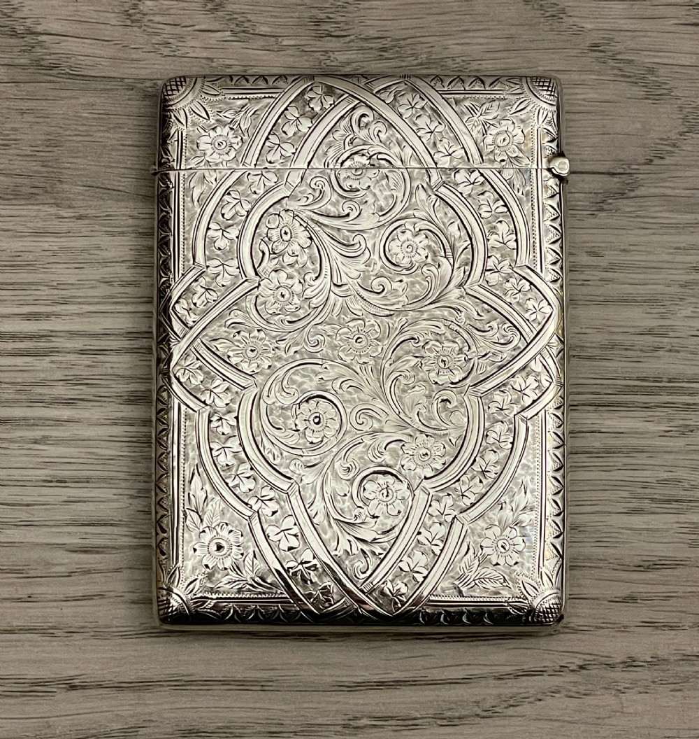 An Edwardian sterling silver calling card case featuring detailed foliate floral engraving and a central monogram cartouche. View VI