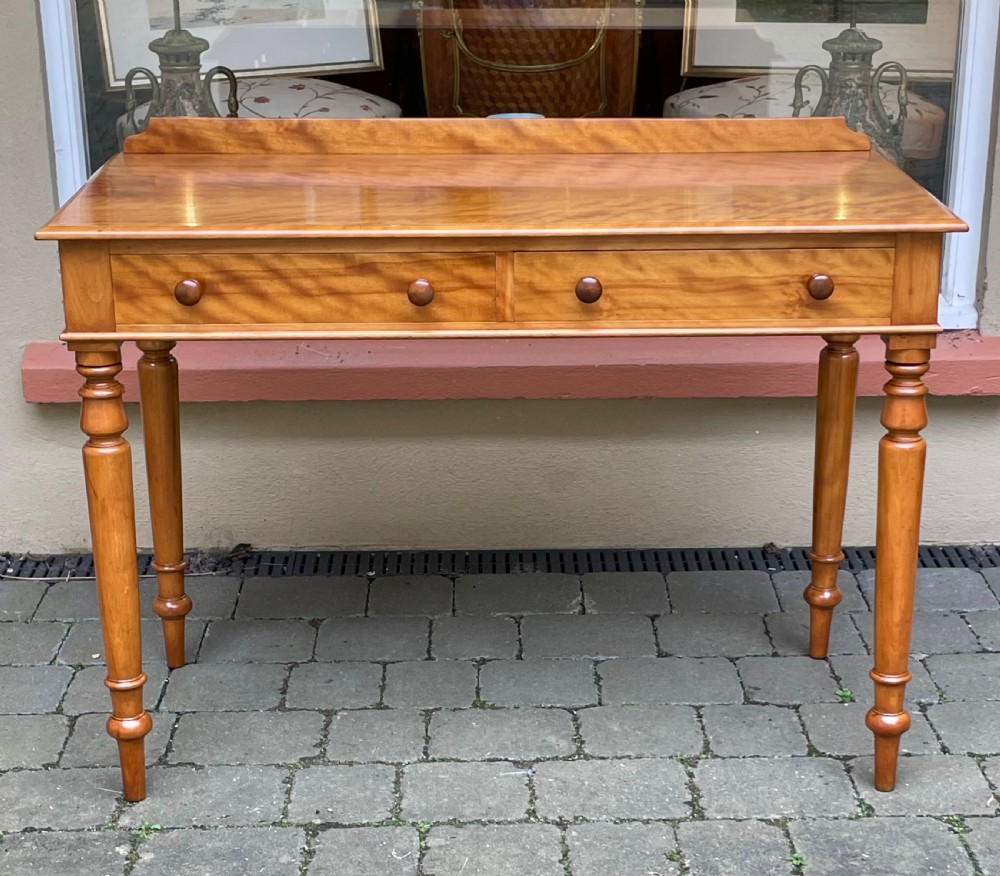 A Victorian satin birch side table featuring a low rear gallery, two front drawers with turned wooden knobs, and four turned tapered legs. View III