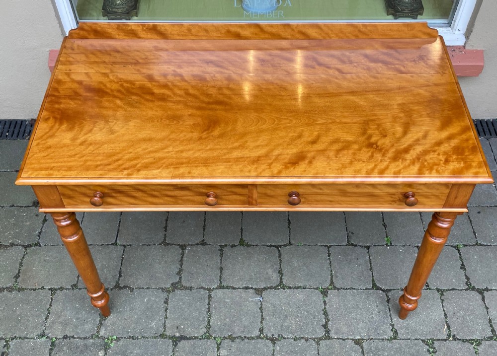 A Victorian satin birch side table featuring a low rear gallery, two front drawers with turned wooden knobs, and four turned tapered legs. View VII