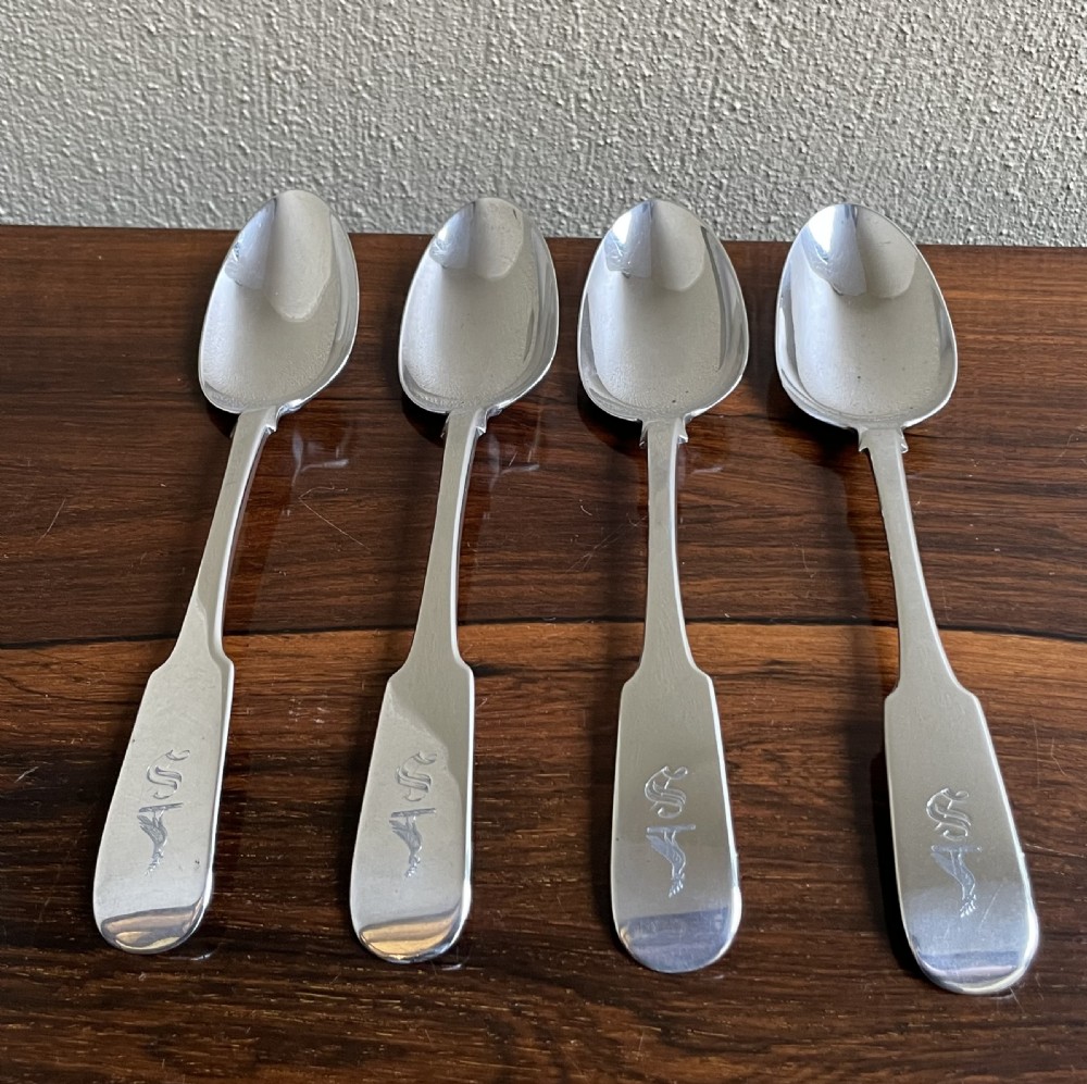 A set of four Victorian Irish sterling silver table spoons with fiddle pattern handles and engraved monograms.