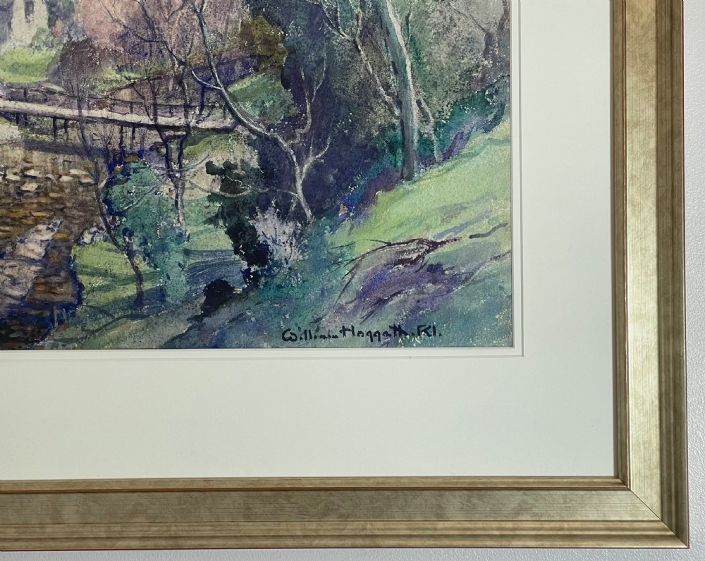 A framed watercolour landscape painting depicting a flowing stream with a wooden footbridge, stone cottages, and distant hills. View II