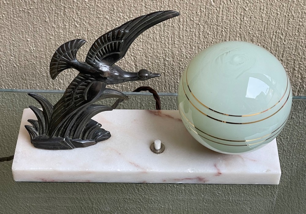 A French Art Deco table lamp featuring a dark patinated spelter bird figure and a frosted green glass globe shade mounted on a rectangular pink marble base. View III