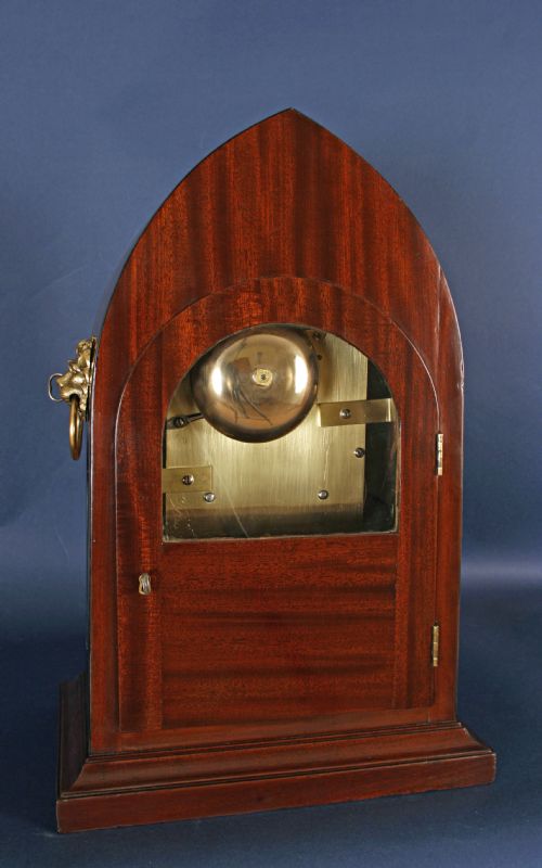 fig 1. A Regency gothic arch mahogany bracket clock with brass lion mask side handles and a white dial inscribed Mitchell and Russell Glasgow.