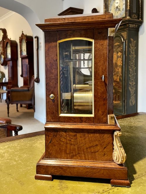 fig 2. A Victorian pollard oak bracket clock featuring an engraved white dial, Roman numerals, and gilt scrollwork accents.