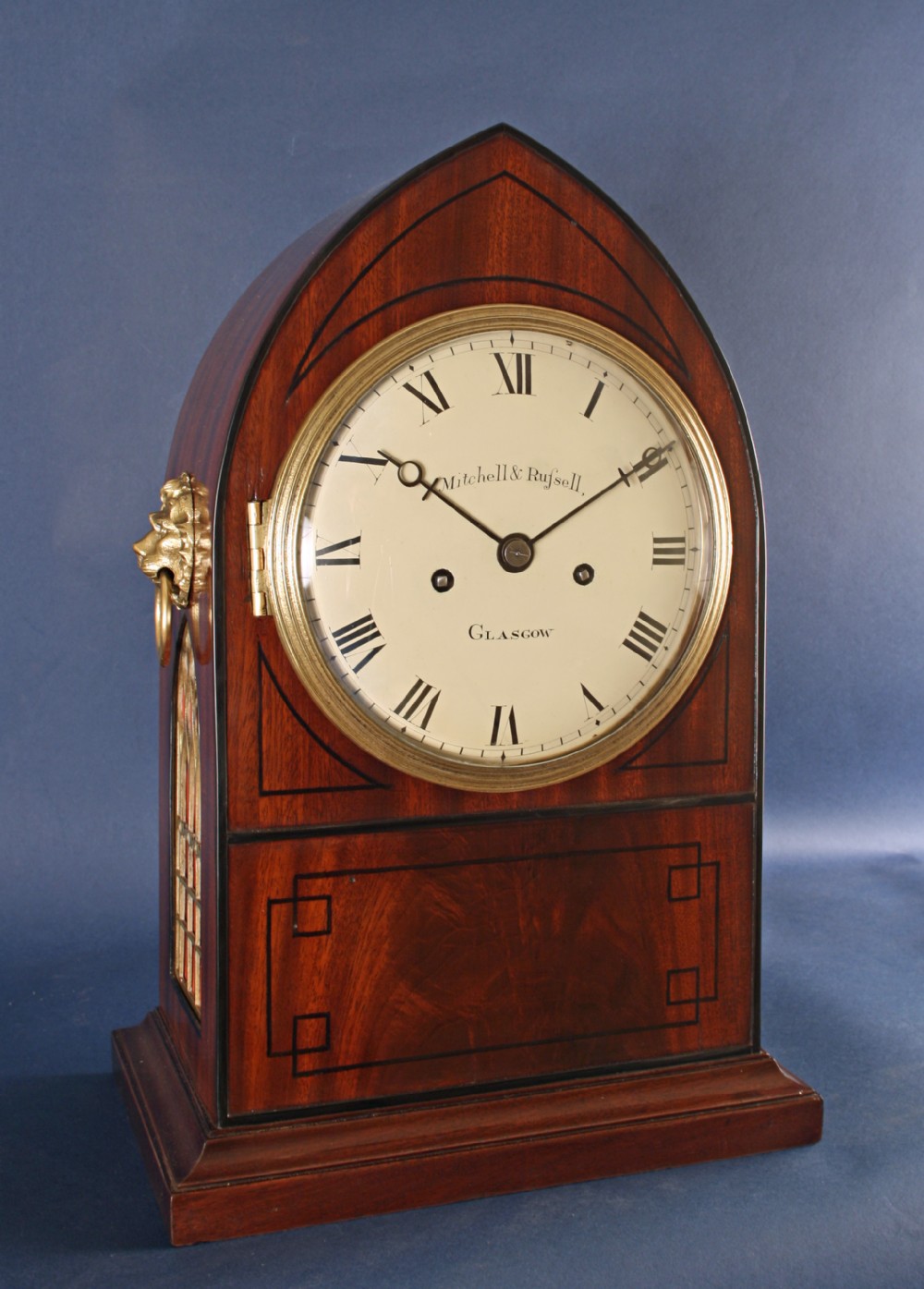 A Regency gothic arch mahogany bracket clock with brass lion mask side handles and a white dial inscribed Mitchell and Russell Glasgow.