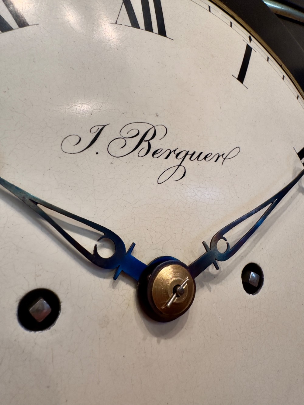 An antique Regency ebonised bracket clock with brass mounts, pineapple finial, ball feet, and a white dial signed J. Berguer Strand London. View II