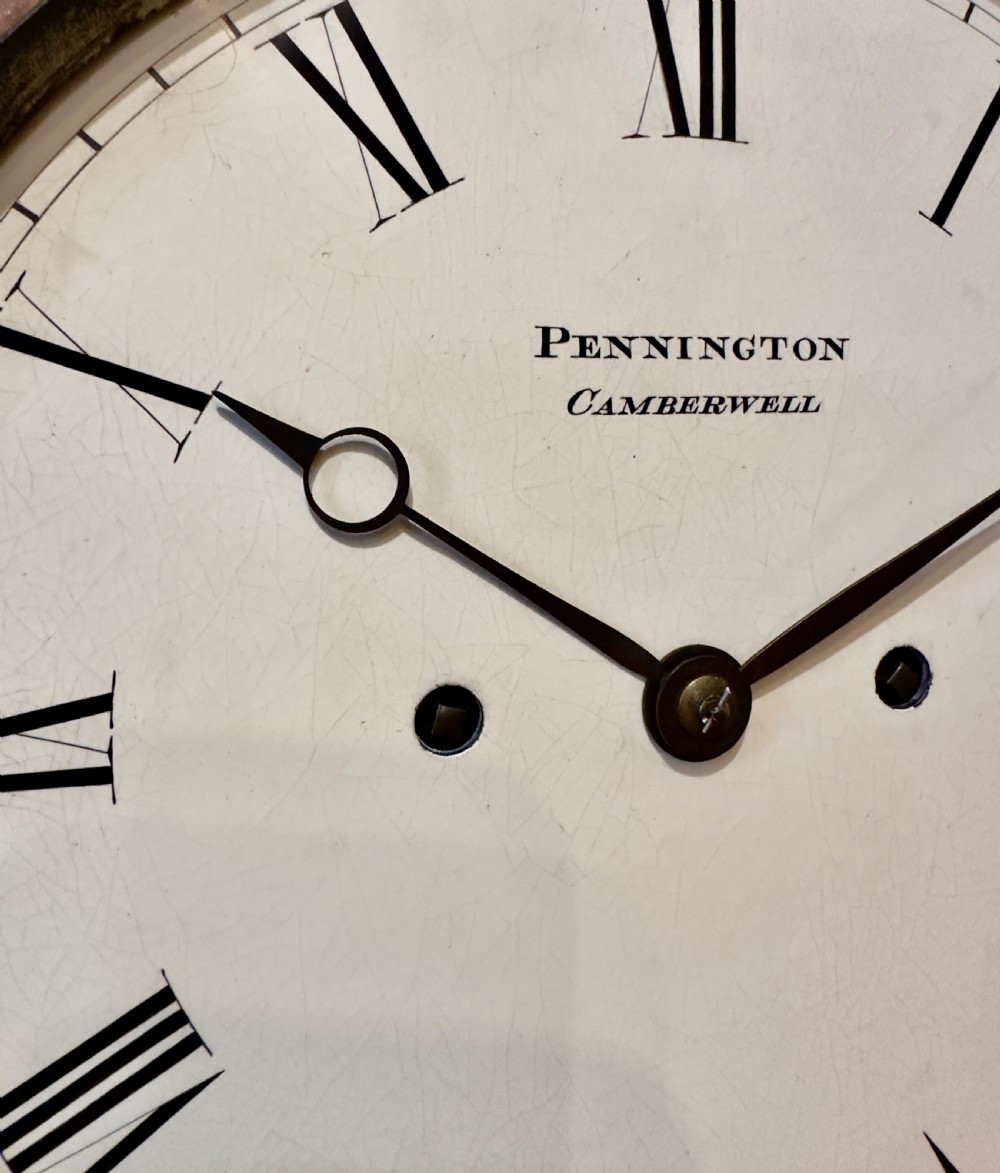 A rectangular pollard oak bracket clock featuring a shaped top, circular white dial with Roman numerals, and decorative side sound frets. View II