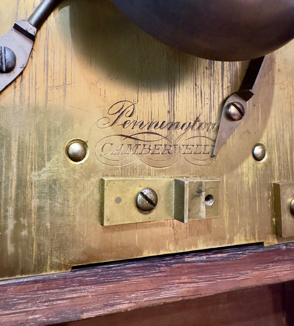 A rectangular pollard oak bracket clock featuring a shaped top, circular white dial with Roman numerals, and decorative side sound frets. View III