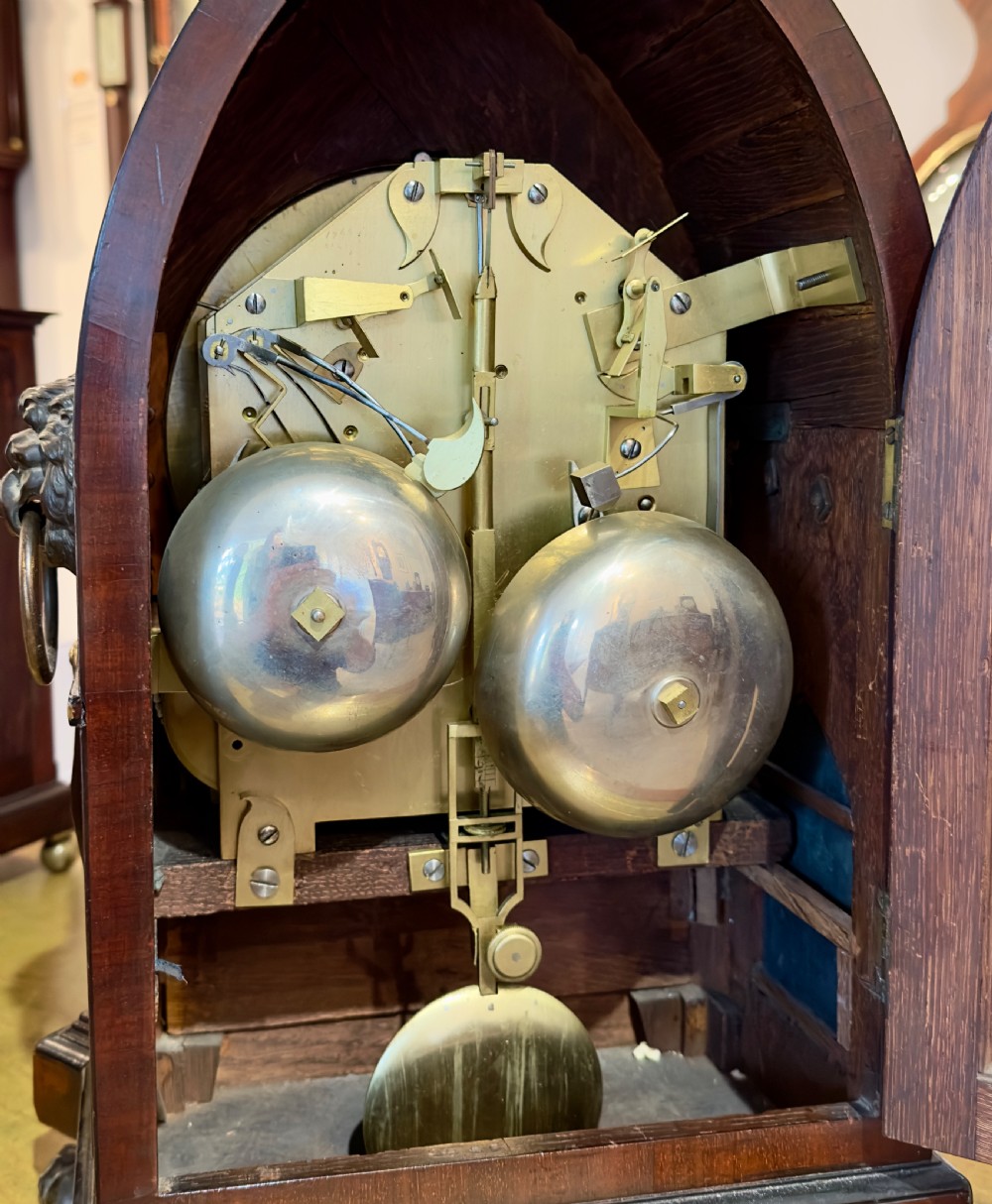 An antique pointed-arch mahogany bracket clock featuring brass Egyptian pharaoh mounts, lion head side handles, and a dial signed Brockbanks London. View III