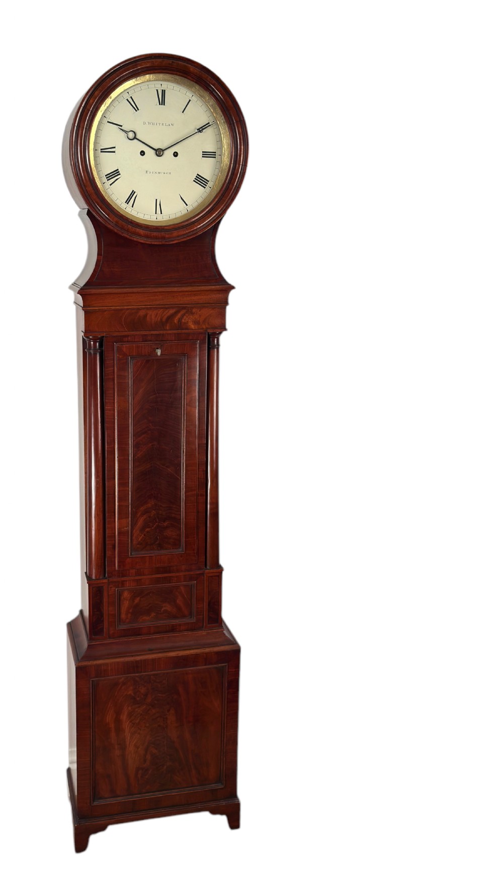 A Scottish Regency flame mahogany longcase clock featuring a circular brass-rimmed dial with Roman numerals and a veneered trunk on bracket feet.