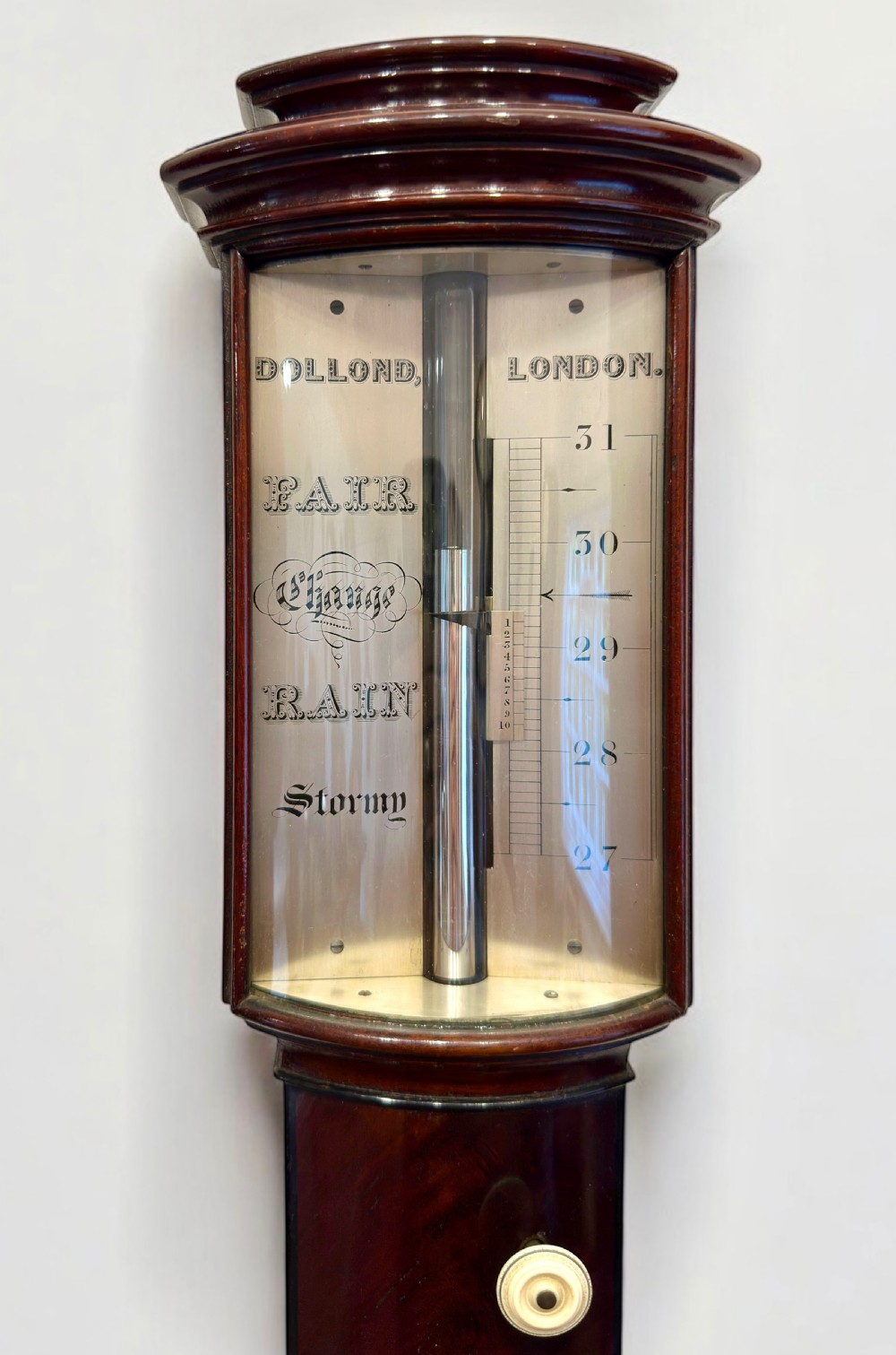 An antique mahogany bow-fronted stick barometer featuring an engraved silvered register plate, an inset glass-encased thermometer, and a turned cistern cover at the base. View III