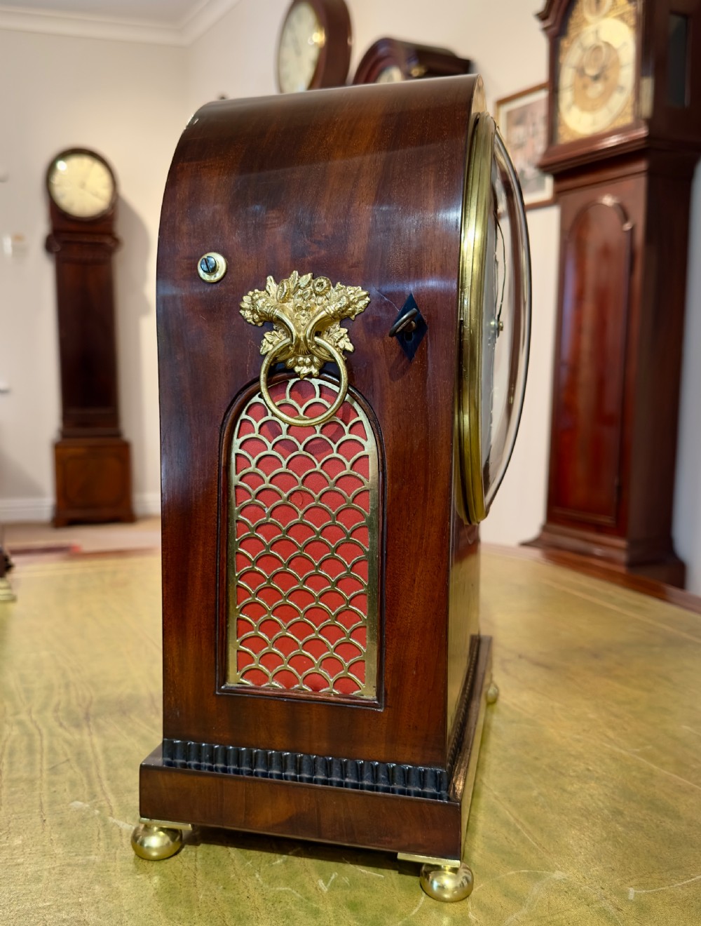 An arched antique mahogany bracket clock with brass scroll inlay, lion-mask ring handles, and a white dial signed Hyde Salisbury. View IV