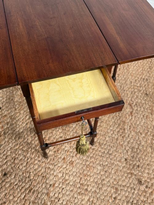fig 3. An Edwardian solid dark mahogany drop-leaf side table featuring turned faux-bamboo legs, a central drawer with a key, and a double-tier stretcher base.