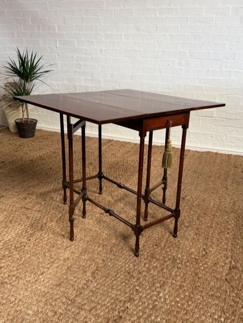 fig 5. An Edwardian solid dark mahogany drop-leaf side table featuring turned faux-bamboo legs, a central drawer with a key, and a double-tier stretcher base.
