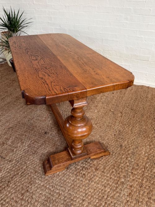 fig 1. A small solid oak refectory style dining table featuring bulbous turned baluster legs and a floor-level central stretcher.
