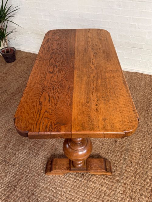 fig 2. A small solid oak refectory style dining table featuring bulbous turned baluster legs and a floor-level central stretcher.