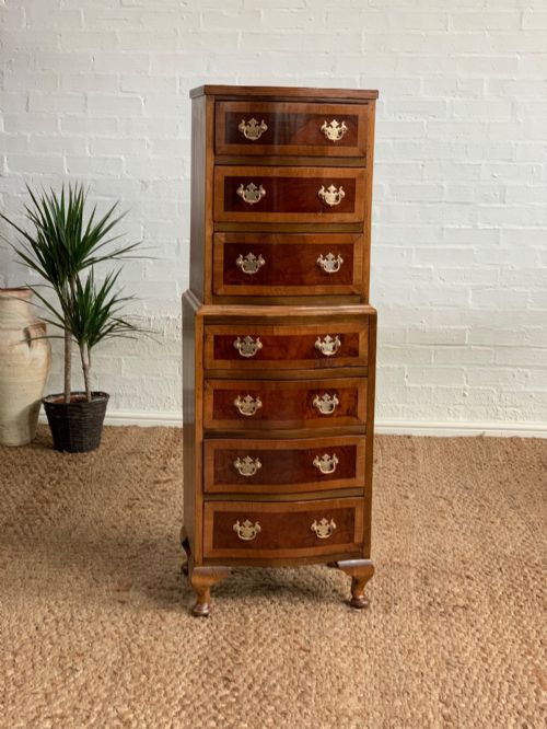 fig 1. A narrow Queen Anne style walnut tallboy featuring seven drawers in a two-piece stacked design with brass handles and cabriole legs.