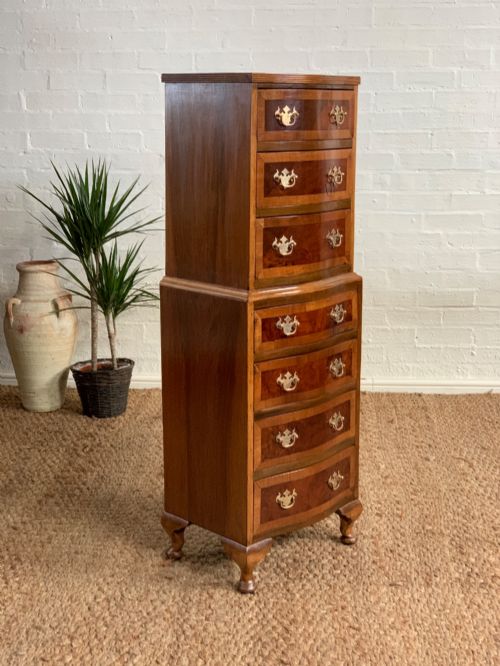 fig 2. A narrow Queen Anne style walnut tallboy featuring seven drawers in a two-piece stacked design with brass handles and cabriole legs.