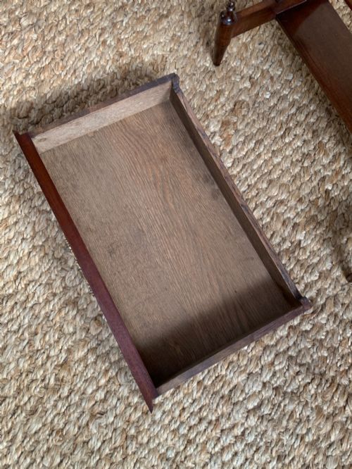 fig 4. A dark mahogany Canterbury side table featuring a rectangular top, a single shallow drawer with brass knobs, and a lower V-shaped magazine trough supported on shaped uprights.