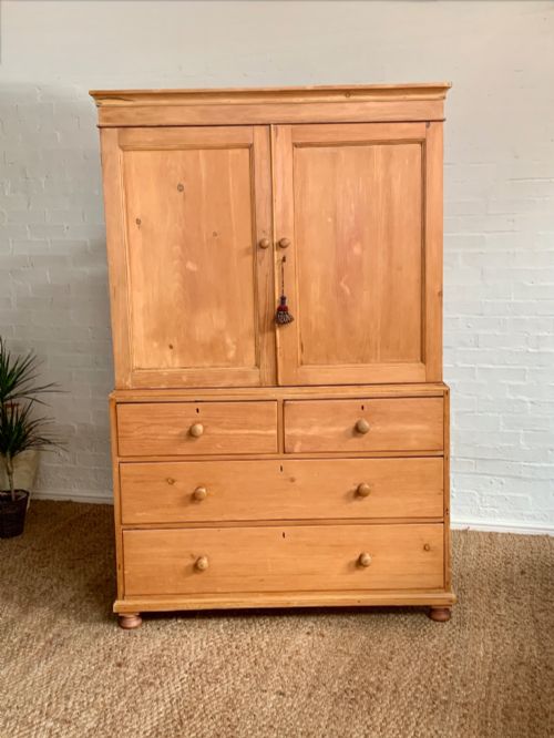 fig 1. A two-piece late Victorian stripped pine dresser featuring a two-door upper cupboard and a base with two short over two long drawers with turned knobs.