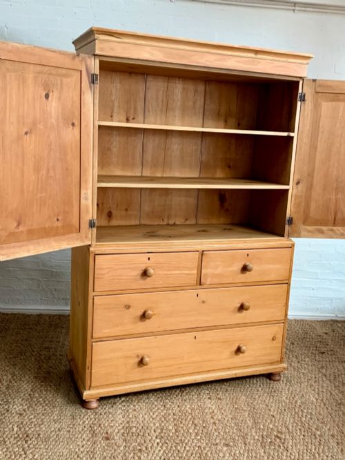 fig 2. A two-piece late Victorian stripped pine dresser featuring a two-door upper cupboard and a base with two short over two long drawers with turned knobs.