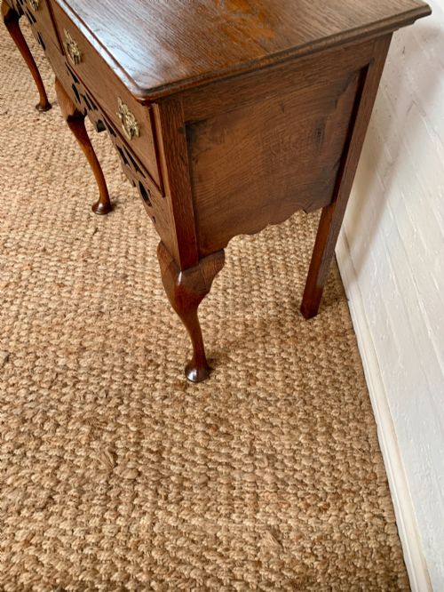 fig 3. An Edwardian oak dresser base featuring three drawers with brass handles, a decorative pierced fretwork apron, and four cabriole legs terminating in pad feet.