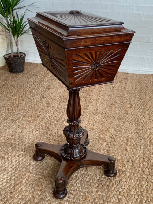 fig 4. A dark rosewood William IV work table featuring a sunburst carved caddy top and side panels supported by a turned column pedestal and quadform base.