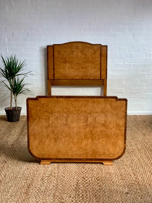 fig 1. An Art Deco single bed frame crafted from figured burr walnut veneer with crossbanded borders, featuring a gently arched headboard and rounded footboard.