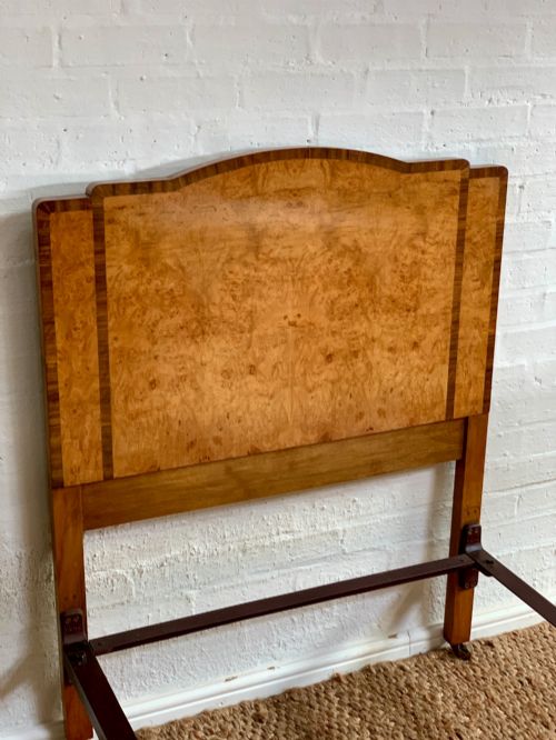 fig 2. An Art Deco single bed frame crafted from figured burr walnut veneer with crossbanded borders, featuring a gently arched headboard and rounded footboard.