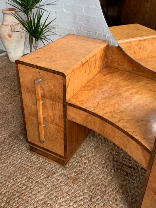 fig 2. An Art Deco burr walnut dressing table featuring a circular mirror, twin pedestals, and vertical drawer handles.