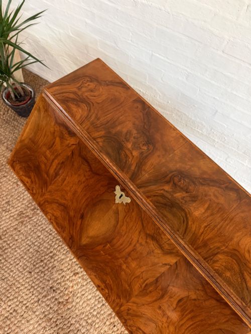 fig 2. A Georgian period figured walnut bureau featuring a slant front flap above four graduated drawers with brass handles, resting on bracket feet.