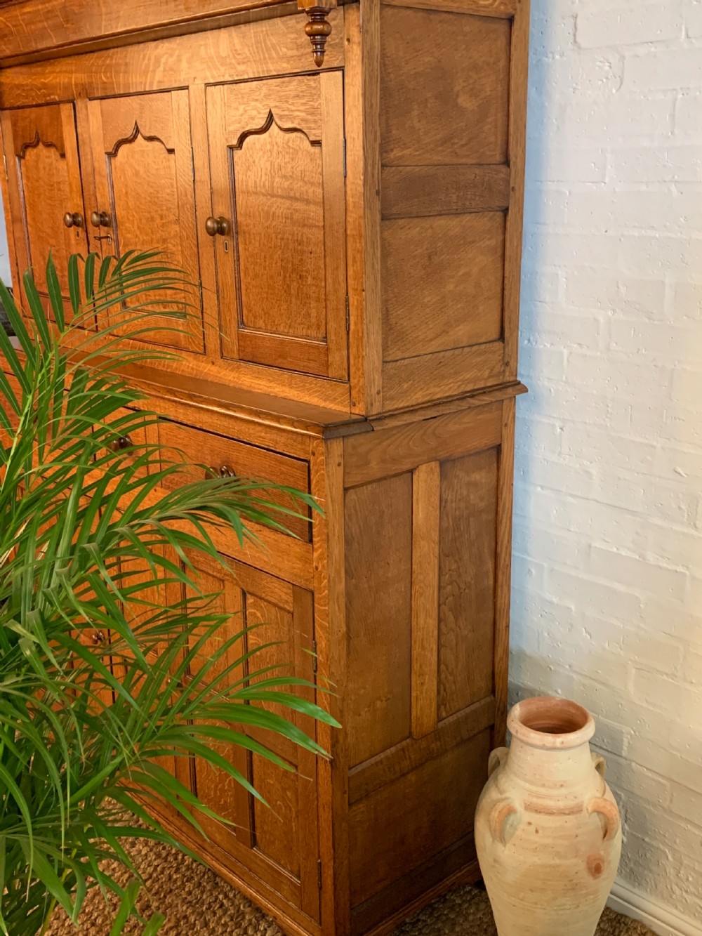 A 19th-century two-tier Welsh oak deuddarn cupboard featuring ogee arched panel doors, turned wooden knobs, and a moulded cornice. View VI