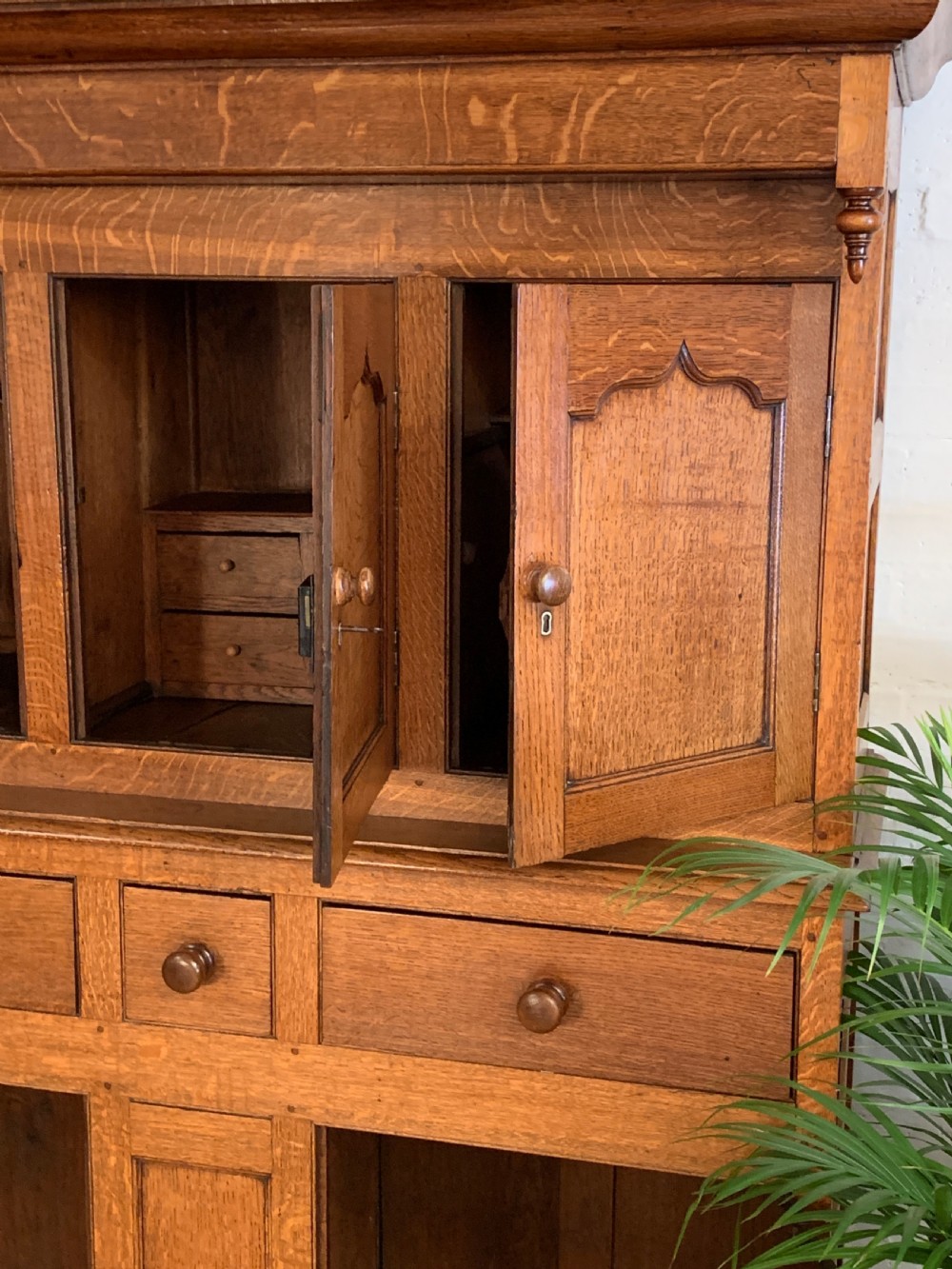 A 19th-century two-tier Welsh oak deuddarn cupboard featuring ogee arched panel doors, turned wooden knobs, and a moulded cornice. View VIII