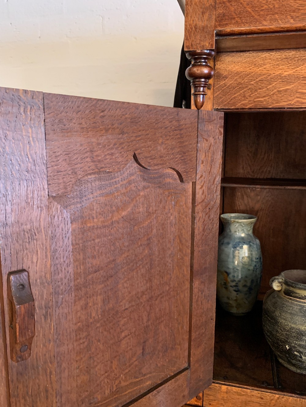 A 19th-century two-tier Welsh oak deuddarn cupboard featuring ogee arched panel doors, turned wooden knobs, and a moulded cornice. View IX