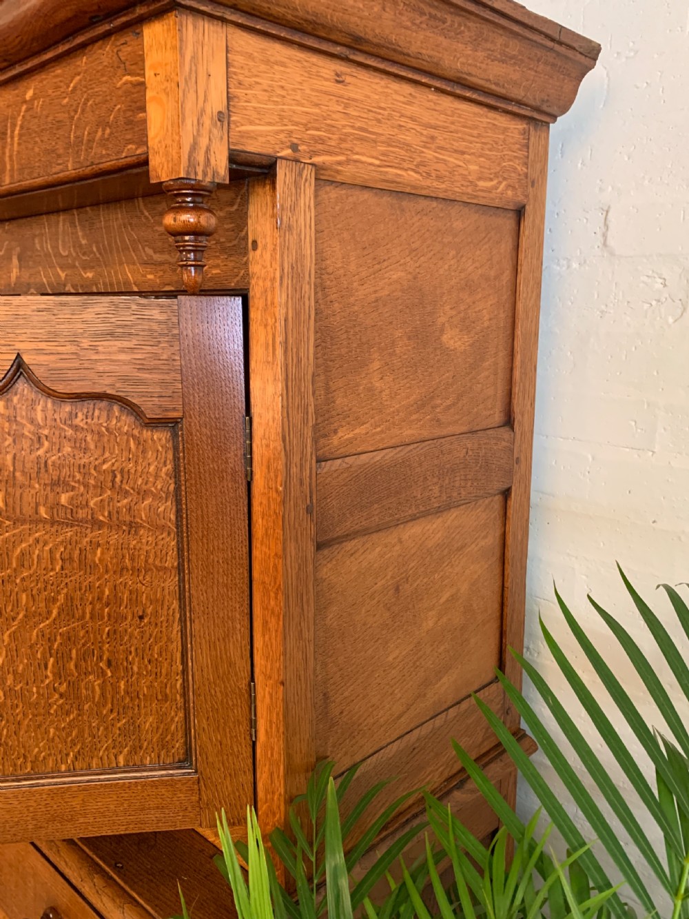 A 19th-century two-tier Welsh oak deuddarn cupboard featuring ogee arched panel doors, turned wooden knobs, and a moulded cornice. View X
