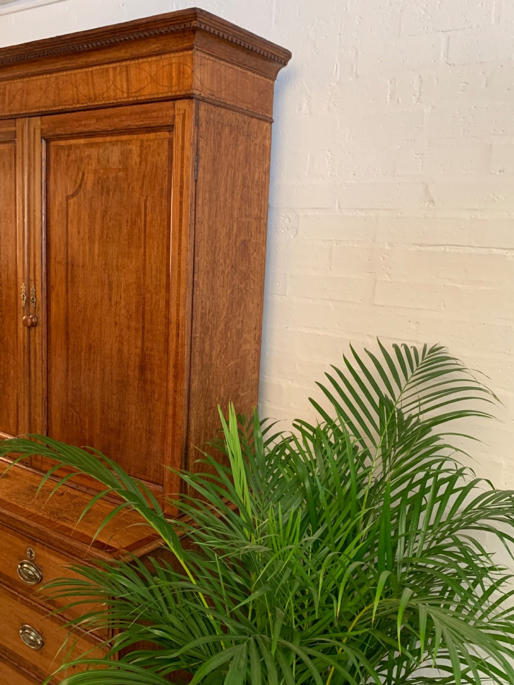A two-stage Georgian oak press cupboard featuring a double-door upper cabinet mounted over a chest of drawers with oval brass handles. View III