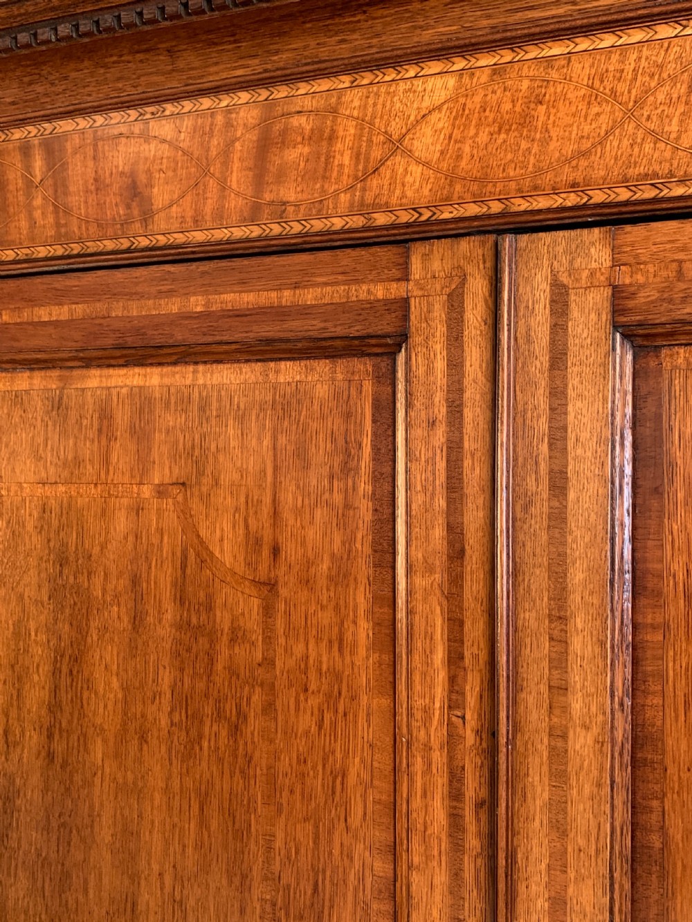 A two-stage Georgian oak press cupboard featuring a double-door upper cabinet mounted over a chest of drawers with oval brass handles. View IV