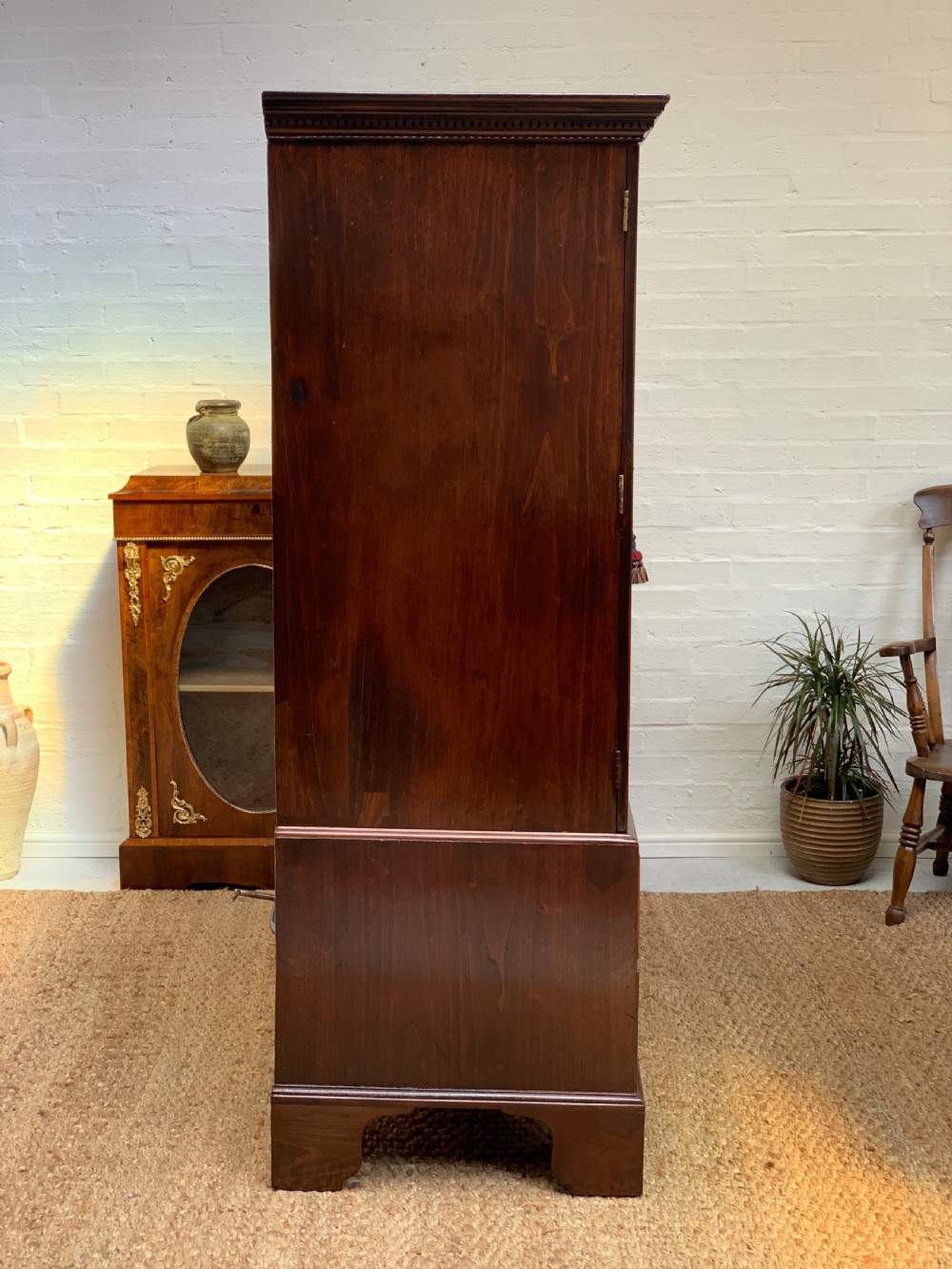A Georgian dark mahogany linen press featuring two large flame mahogany panelled doors with rosewood crossbanding above two wide drawers with oval brass handles. View XII