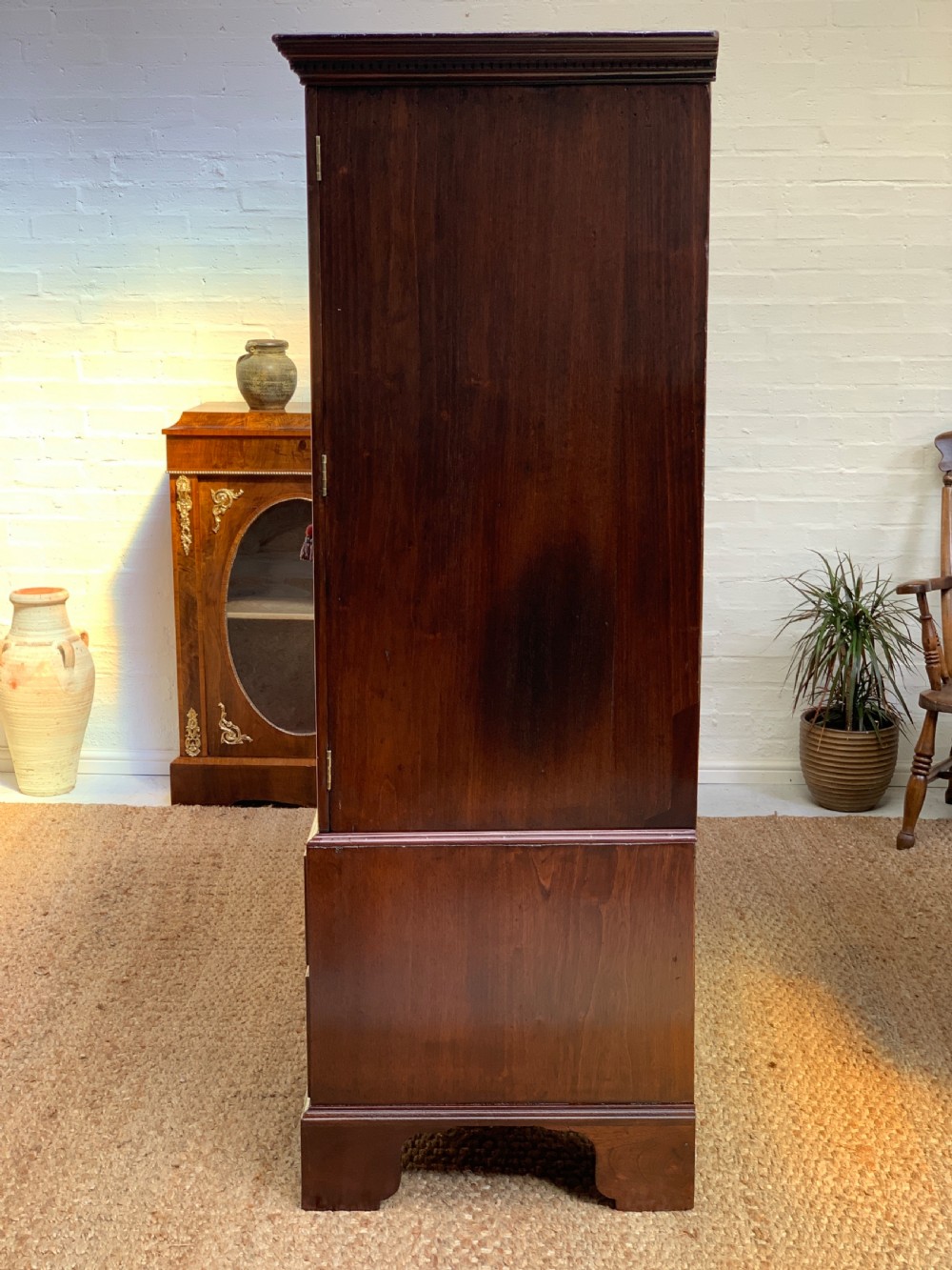 A Georgian dark mahogany linen press featuring two large flame mahogany panelled doors with rosewood crossbanding above two wide drawers with oval brass handles. View XIII